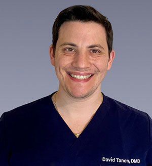 A smiling man with a stethoscope, posing for a professional headshot.