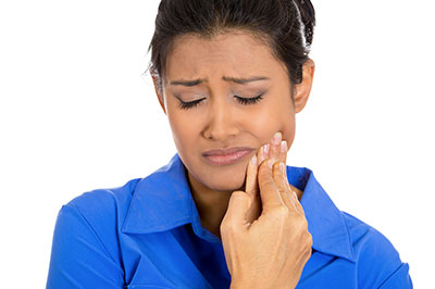 A woman with a concerned expression, holding her mouth and looking upwards.