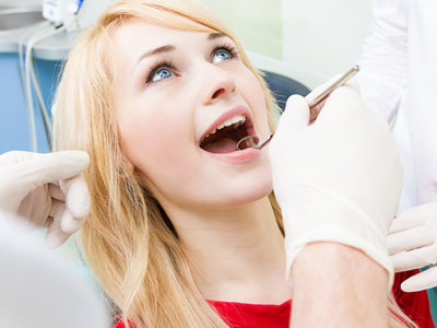 A woman receiving dental care, with a dental professional performing the procedure.